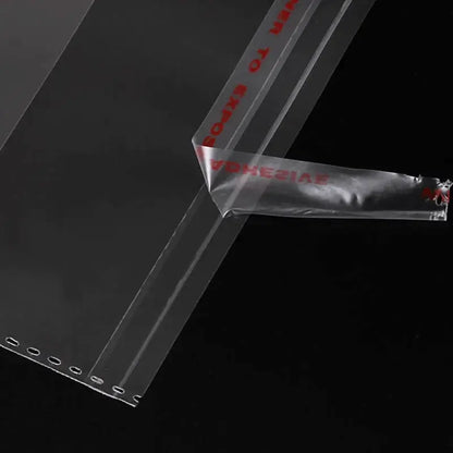 Close-up van een transparant cellofaanzakje met de beschermfolie gedeeltelijk losgetrokken van de plakstrip.